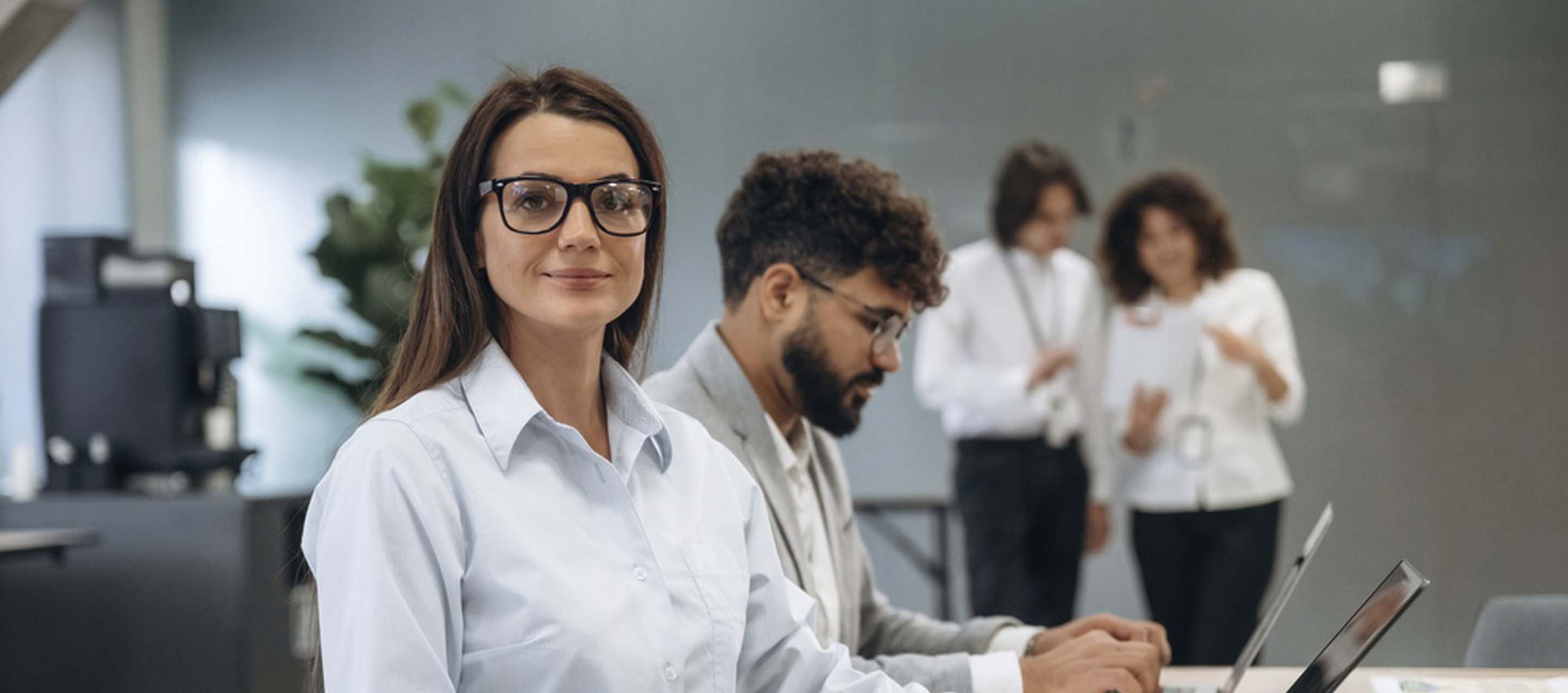 Mujer profesional sonriendo mientras utiliza un software de gestión legal en su ordenador.