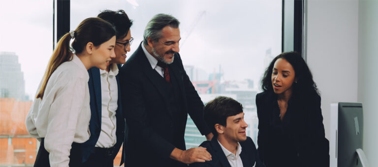 Equipo de abogados y gestores colaborando frente a una pantalla en una oficina moderna.